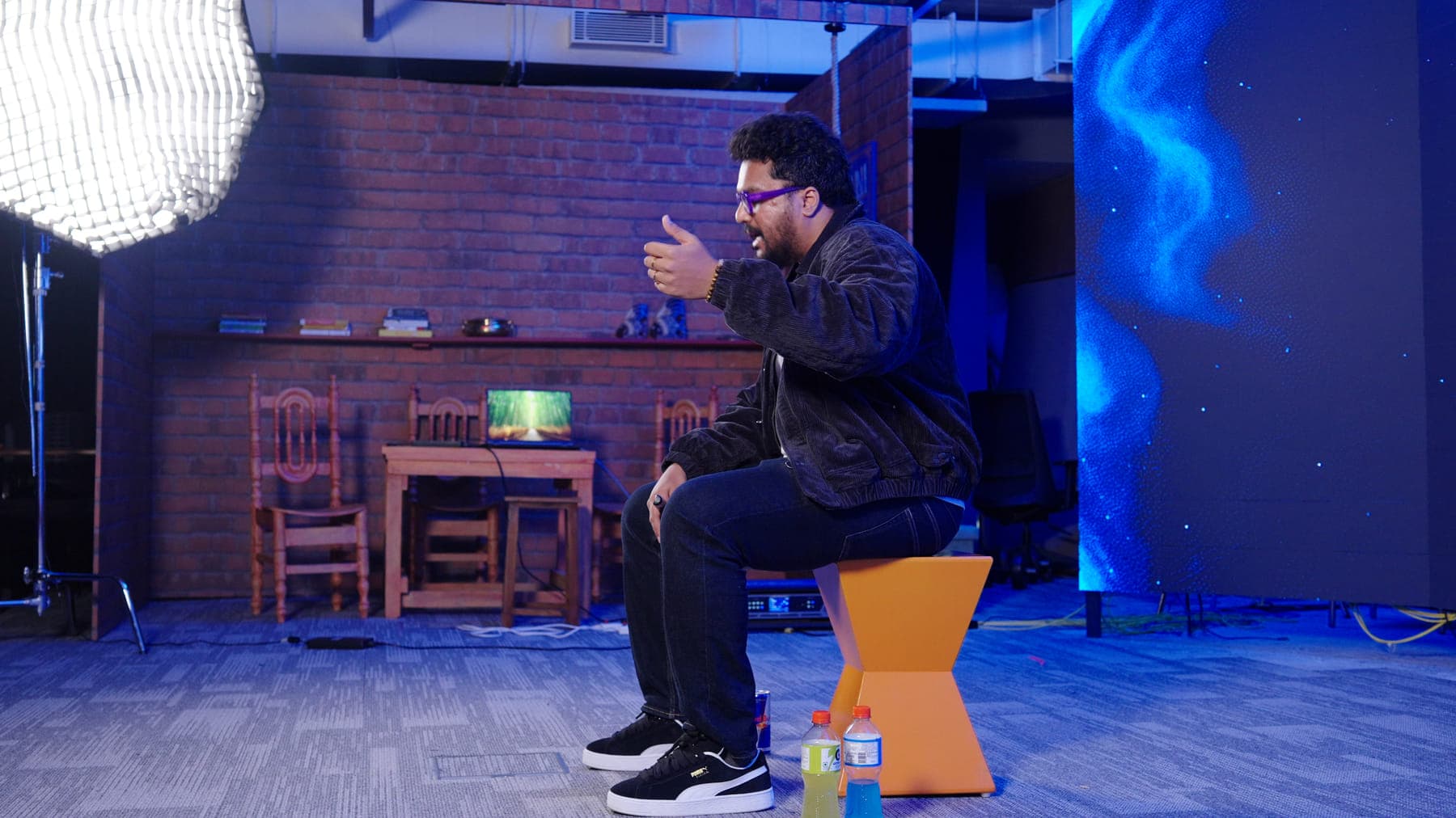 A guest speaker on the GenC stage under blue light