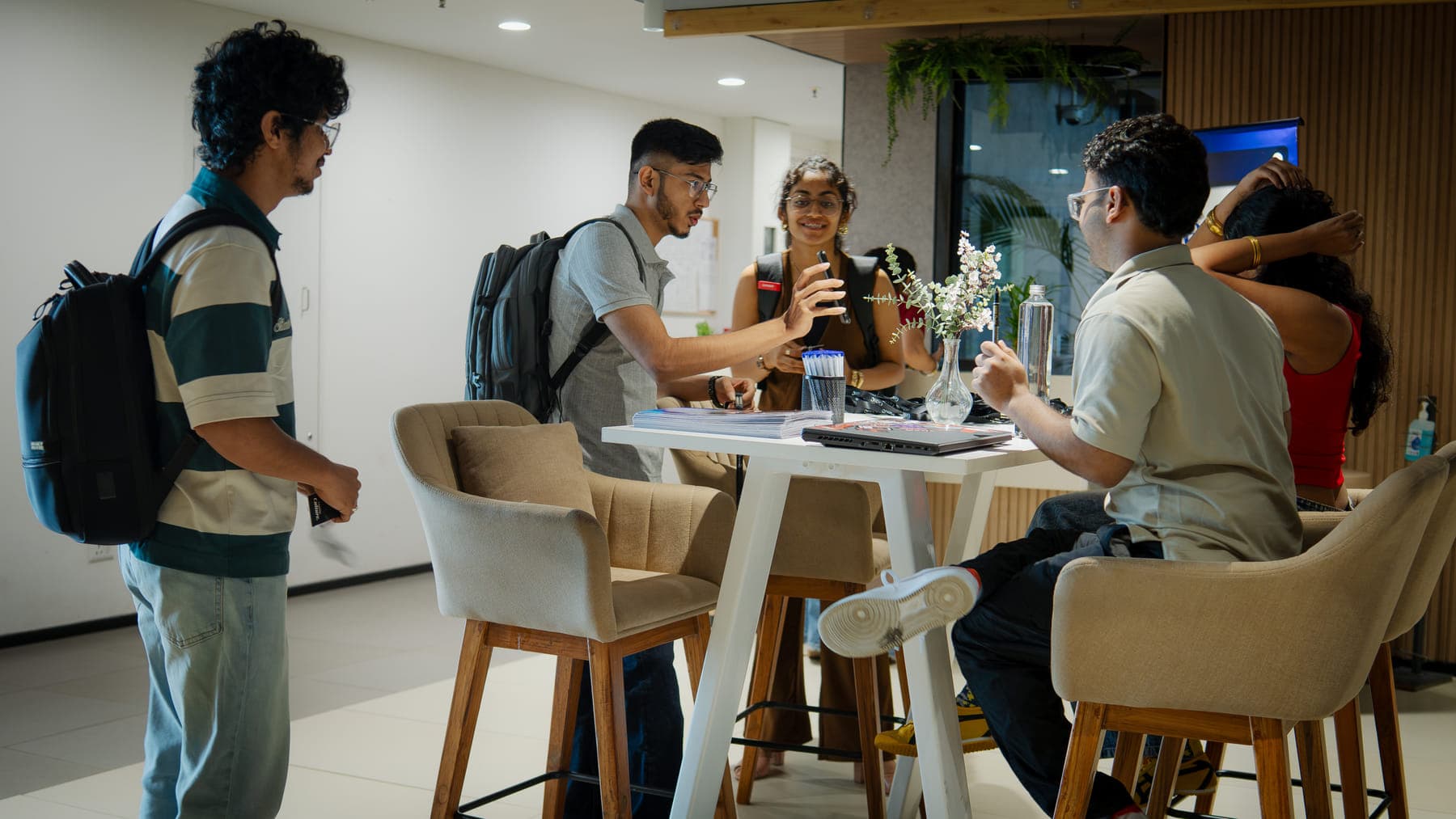 GenC students talking through their work around a table at the studio