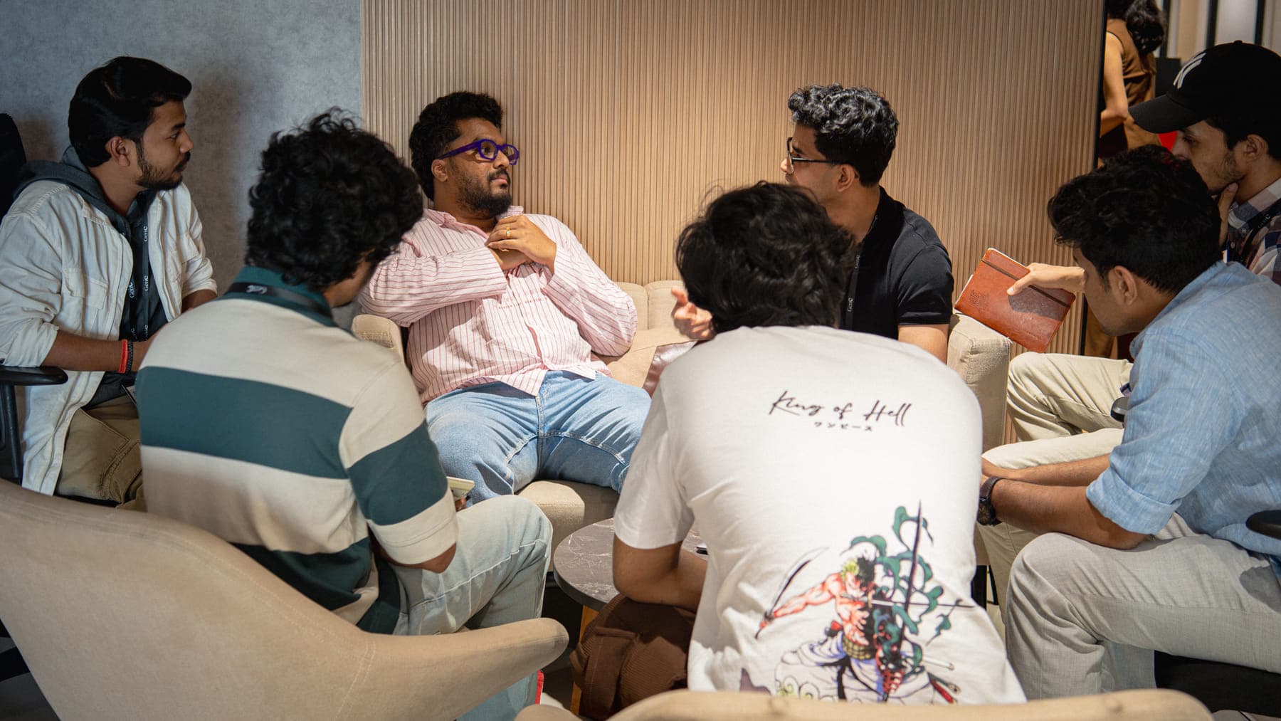 A small group of GenC students in discussion on the studio sofas